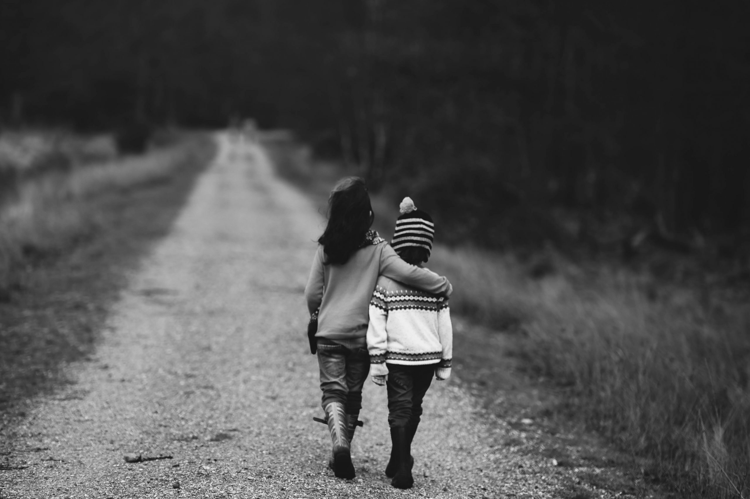 Two children walking down a path together